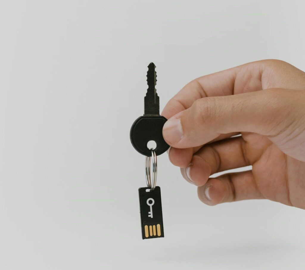 Close-up of a hand holding a key and USB with copyspace.